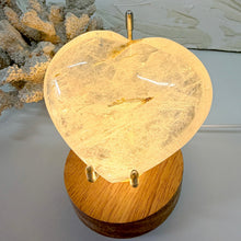 Load image into Gallery viewer, Clear Quartz crystal heart illuminated on a wooden LED light base
